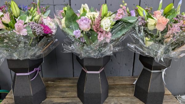garden-of-eden-flower-shop-stocksbridge-florist-choice-bouquet-12 Set of 3 florist choice bouquet of flowers on a wooden display in the garden of eden flower shop