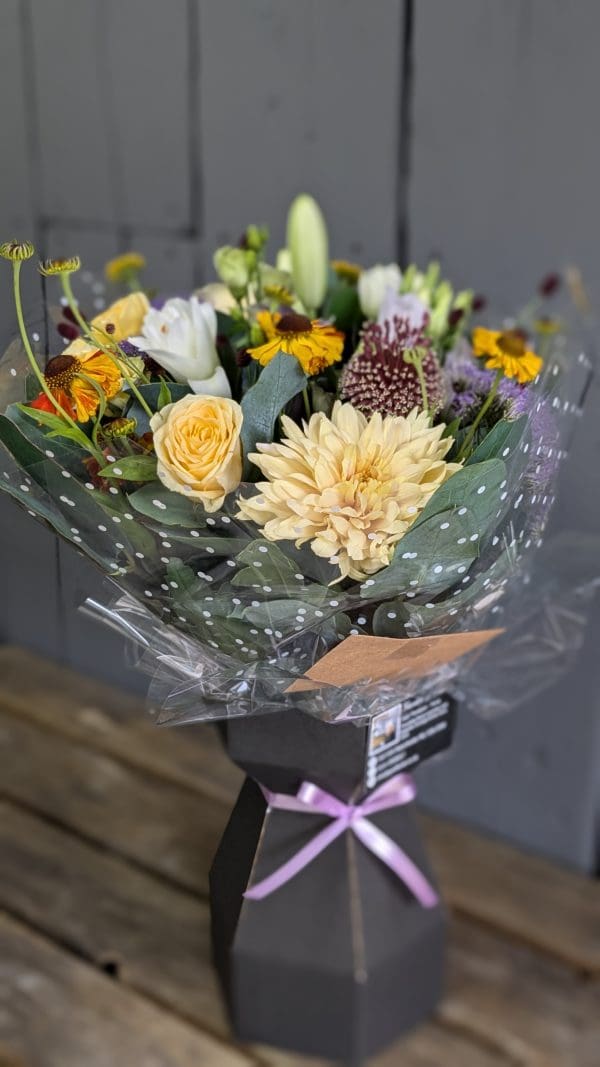 garden-of-eden-florist-colourful-bouquet A bouquet of yellow autumnal coloured flowers from the side