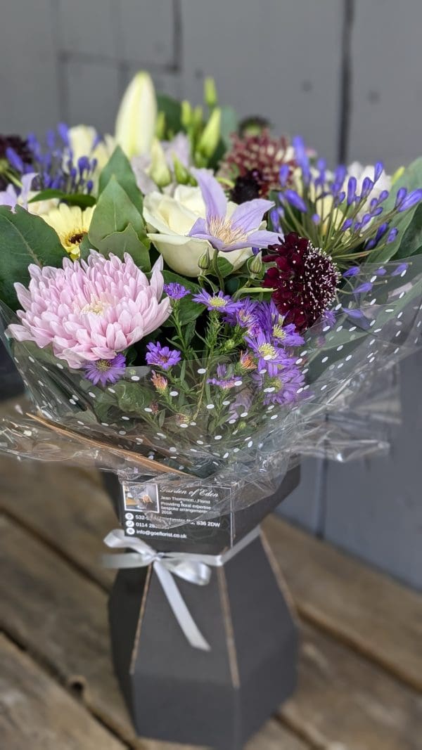 garden-of-eden-florist-special-occasion-bouquet A bouquet of pink and lilac coloured flowers from the side